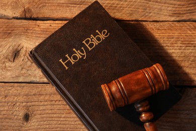 Photo of Judge's gavel and Bible on wooden table, top view