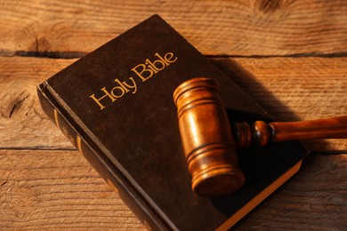 Photo of Judge's gavel and Bible on wooden table, above view