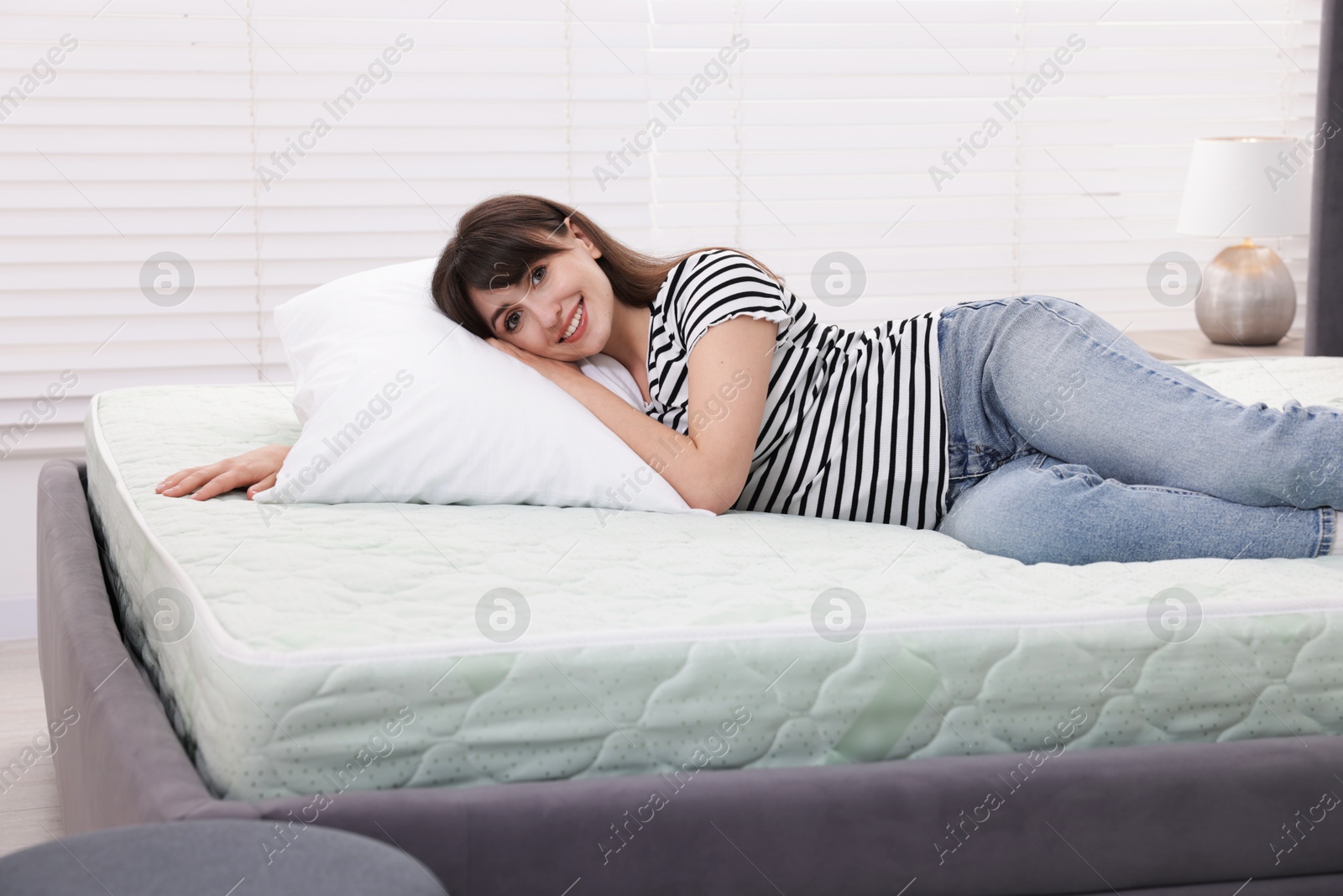 Beautiful woman lying on soft mattress at home Photo of Beautiful woman lying on soft mattress at home
