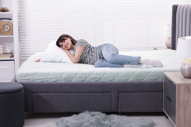 Photo of Beautiful woman lying on soft mattress at home