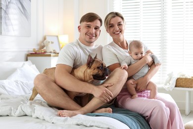 Photo of Happy family with little baby and cute dog on bed at home