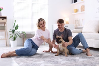 Photo of Happy couple with cute dog at home