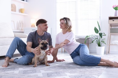Photo of Happy couple with cute dog at home
