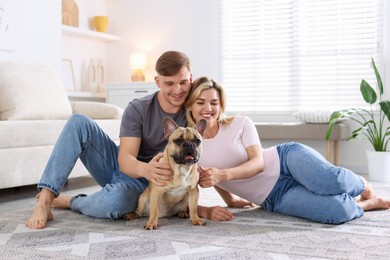 Photo of Happy couple with cute dog at home
