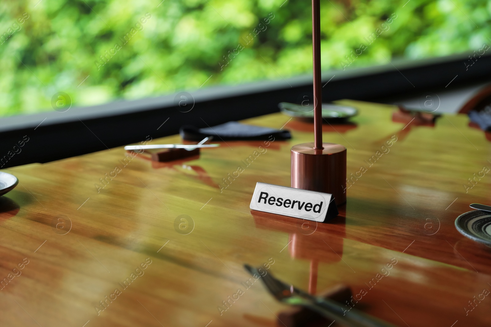 Sign with word Reserved on wooden table in restaurant Photo of Sign with word Reserved on wooden table in restaurant