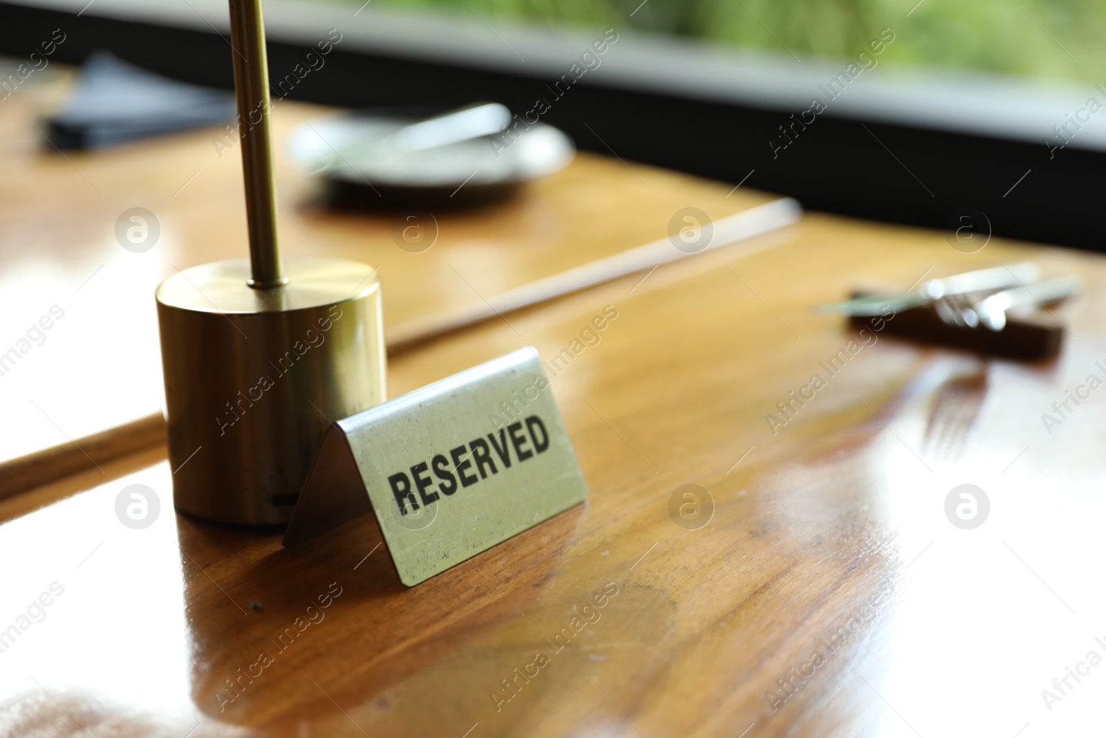 Sign with word Reserved on wooden table in restaurant, closeup. Space for text Photo of Sign with word Reserved on wooden table in restaurant, closeup. Space for text