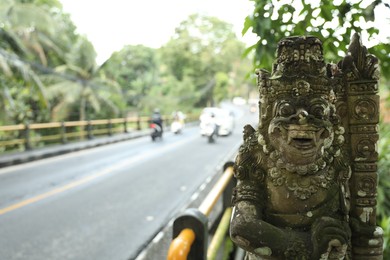 Photo of Bali, Indonesia - May 12, 2025: Old Dvarapala statue near road outdoors, closeup. Space for text