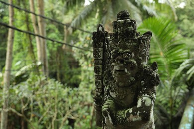 Photo of Bali, Indonesia - May 12, 2025: Old Dvarapala statue in forest, closeup. Space for text