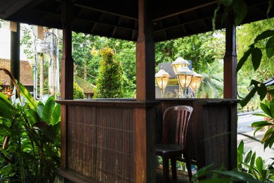 Photo of Wooden terrace and chair near plants in park