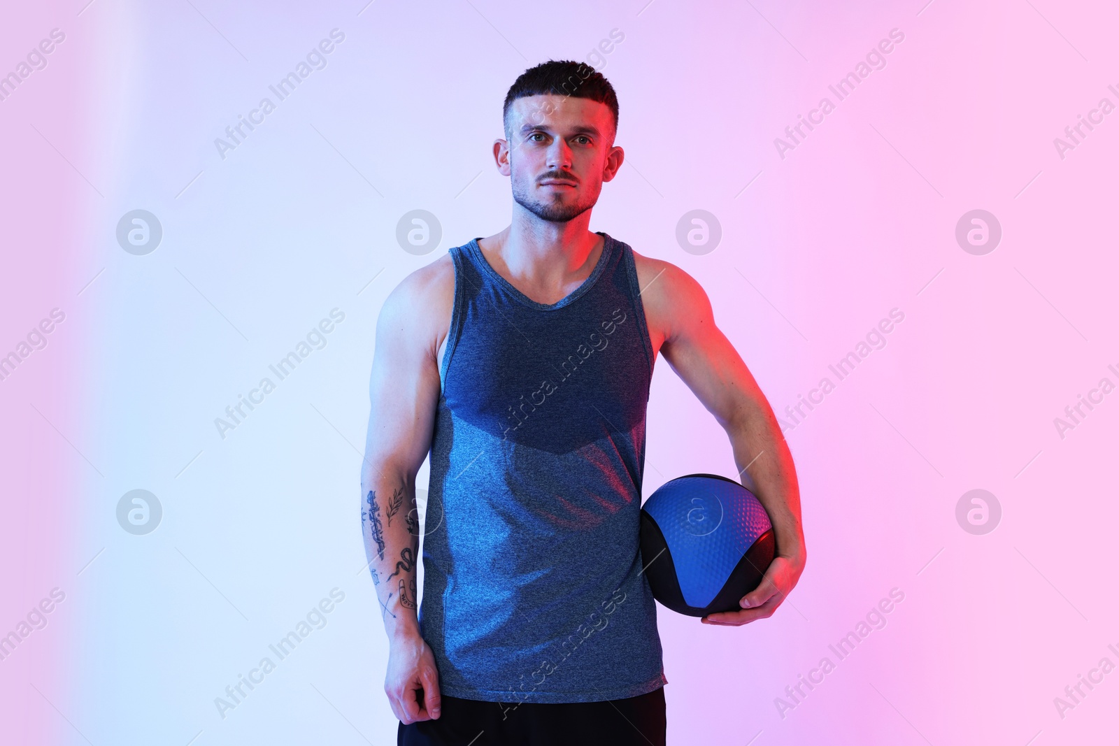 Man with medicine ball on color background Photo of Man with medicine ball on color background