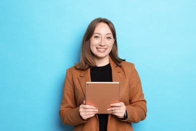 Photo of Woman with modern tablet on light blue background