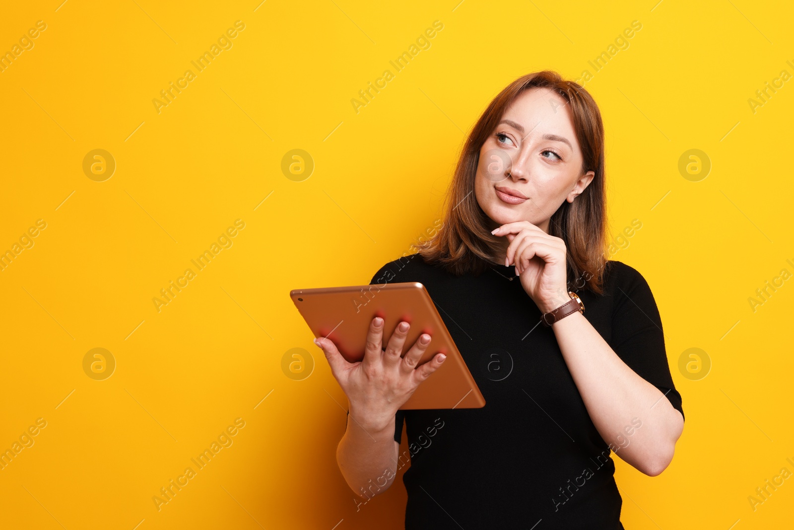 Woman with modern tablet on orange background, space for text Photo of Woman with modern tablet on orange background, space for text
