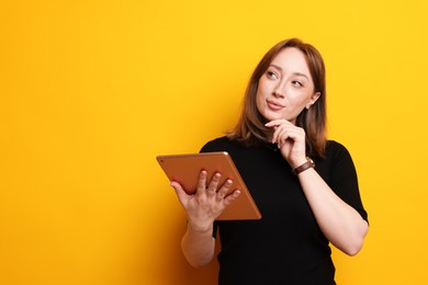 Photo of Woman with modern tablet on orange background, space for text