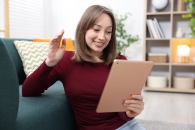Photo of Woman having video chat via on floor at home