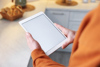 Photo of Man using modern tablet at home, closeup
