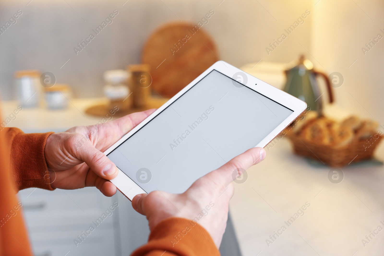 Man using modern tablet at home, closeup Photo of Man using modern tablet at home, closeup