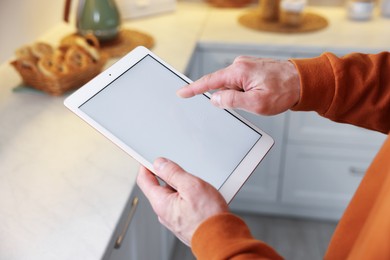 Photo of Man using modern tablet at home, closeup