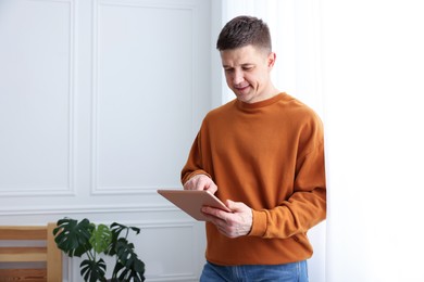 Photo of Man using modern tablet at white wall