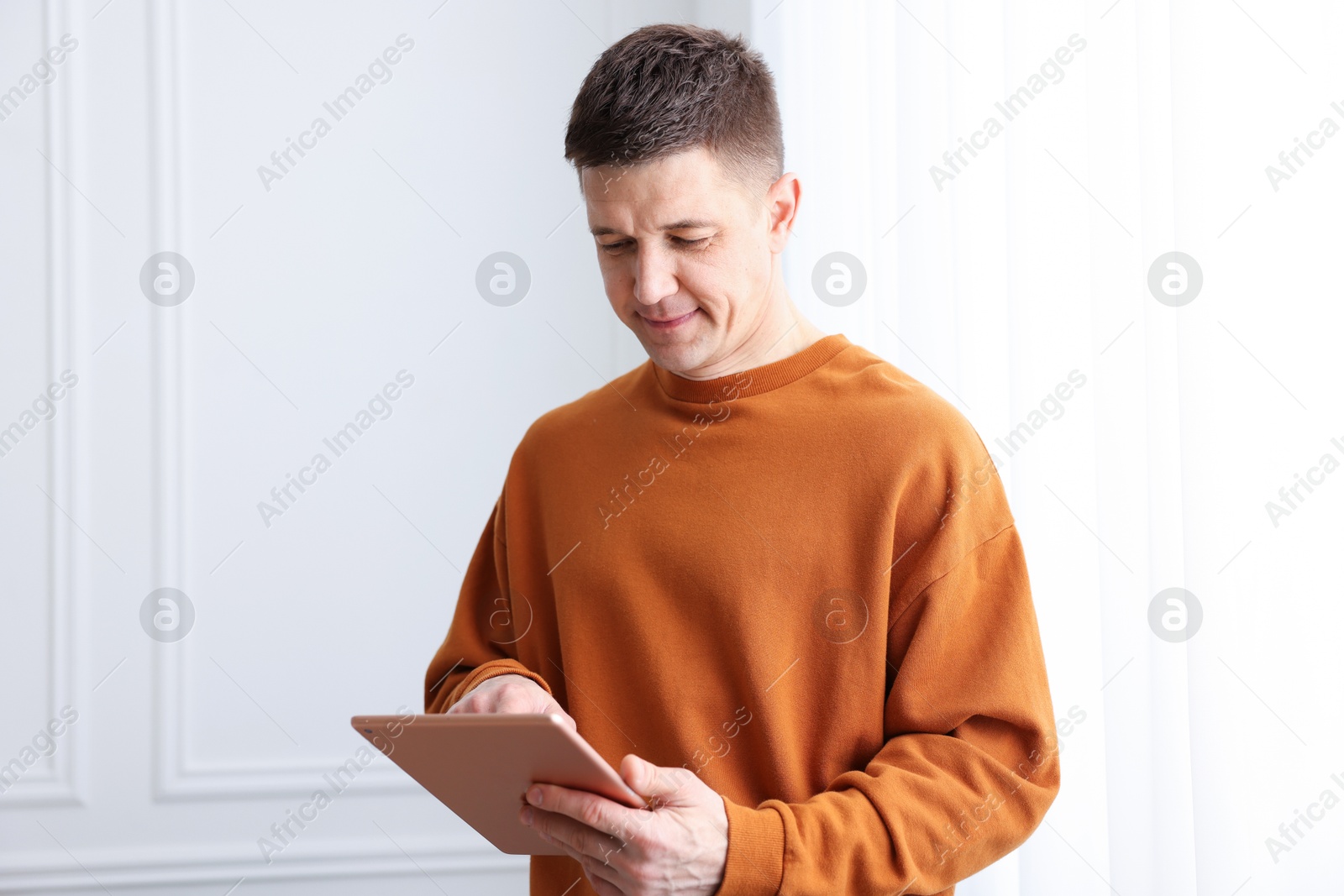 Man using modern tablet at white wall Photo of Man using modern tablet at white wall