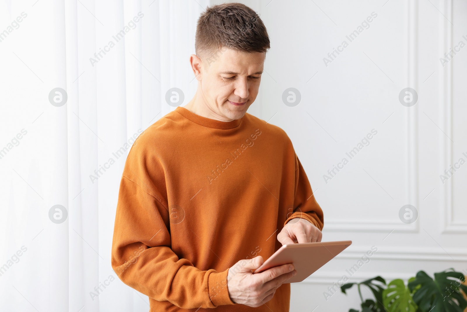 Man using modern tablet at white wall Photo of Man using modern tablet at white wall