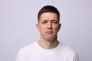 Photo of Portrait of stressed man on light background