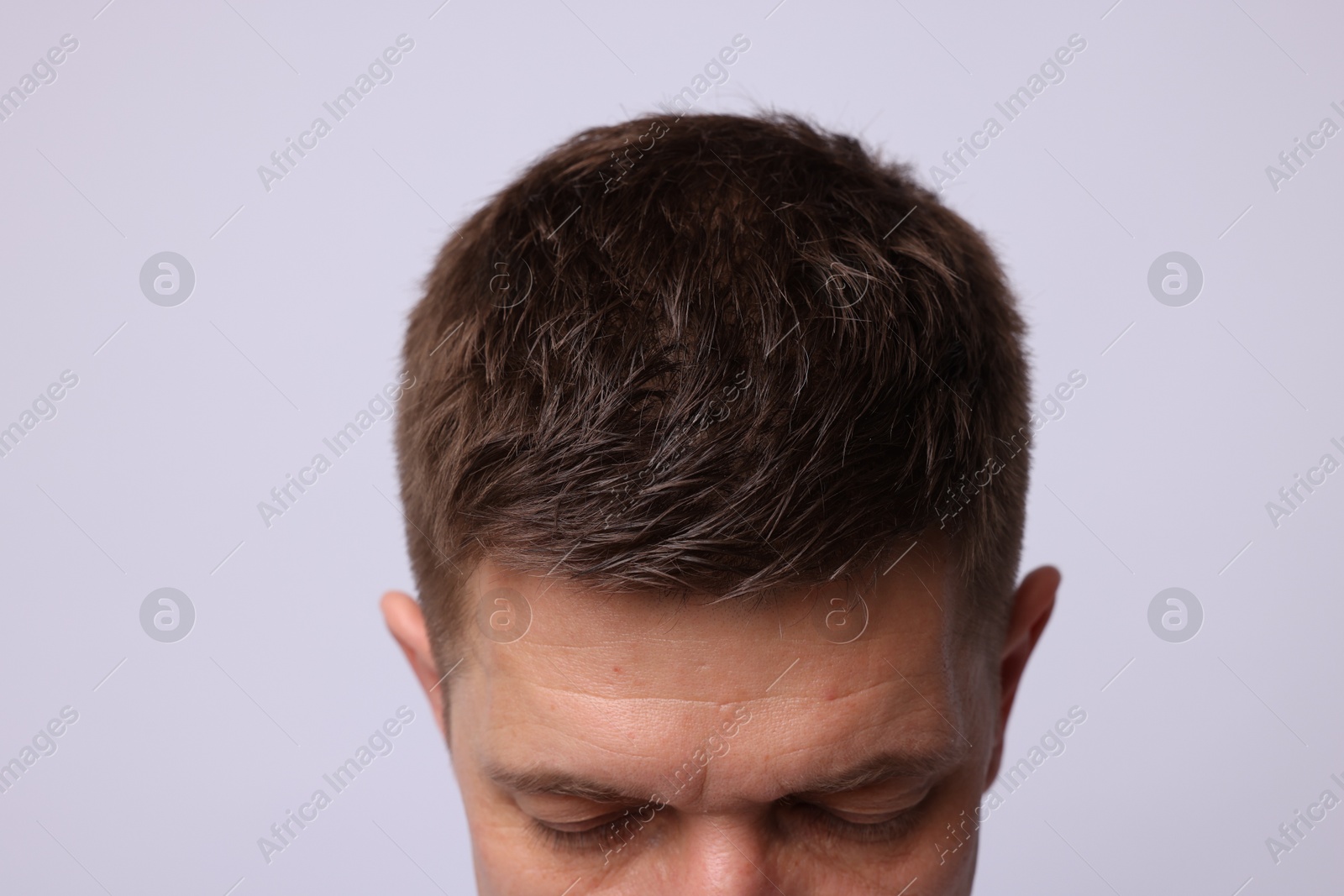 Man with brown hair on light background, closeup Photo of Man with brown hair on light background, closeup