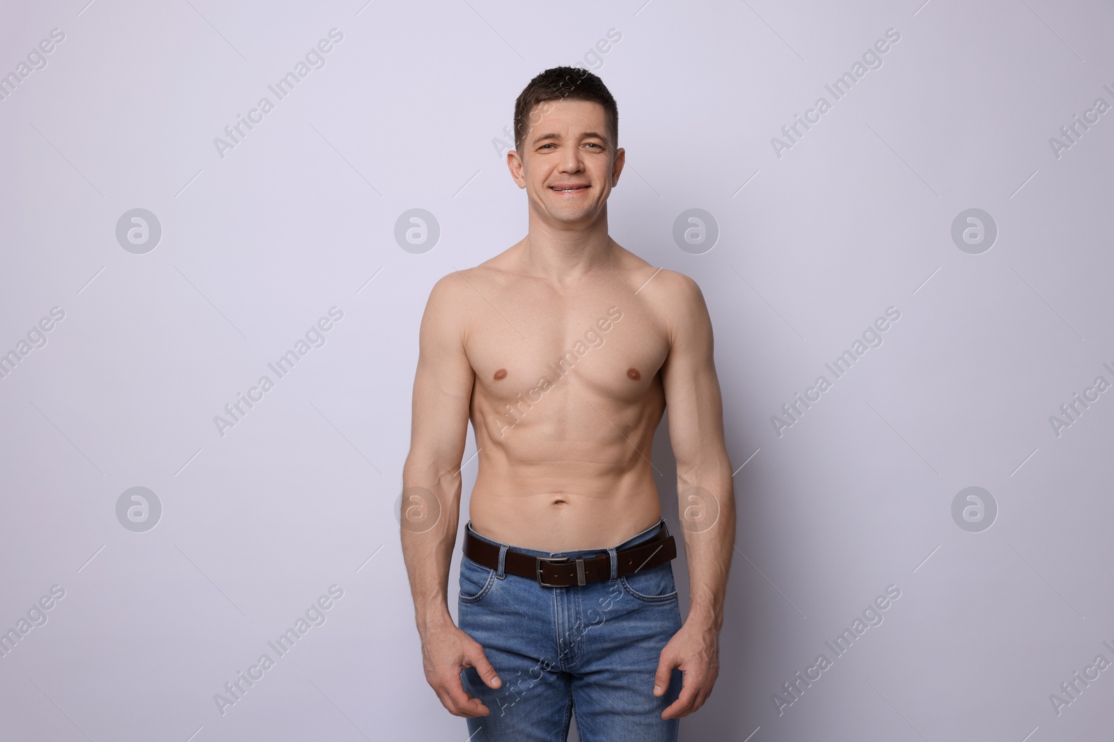 Photo of Confident shirtless man posing on light background