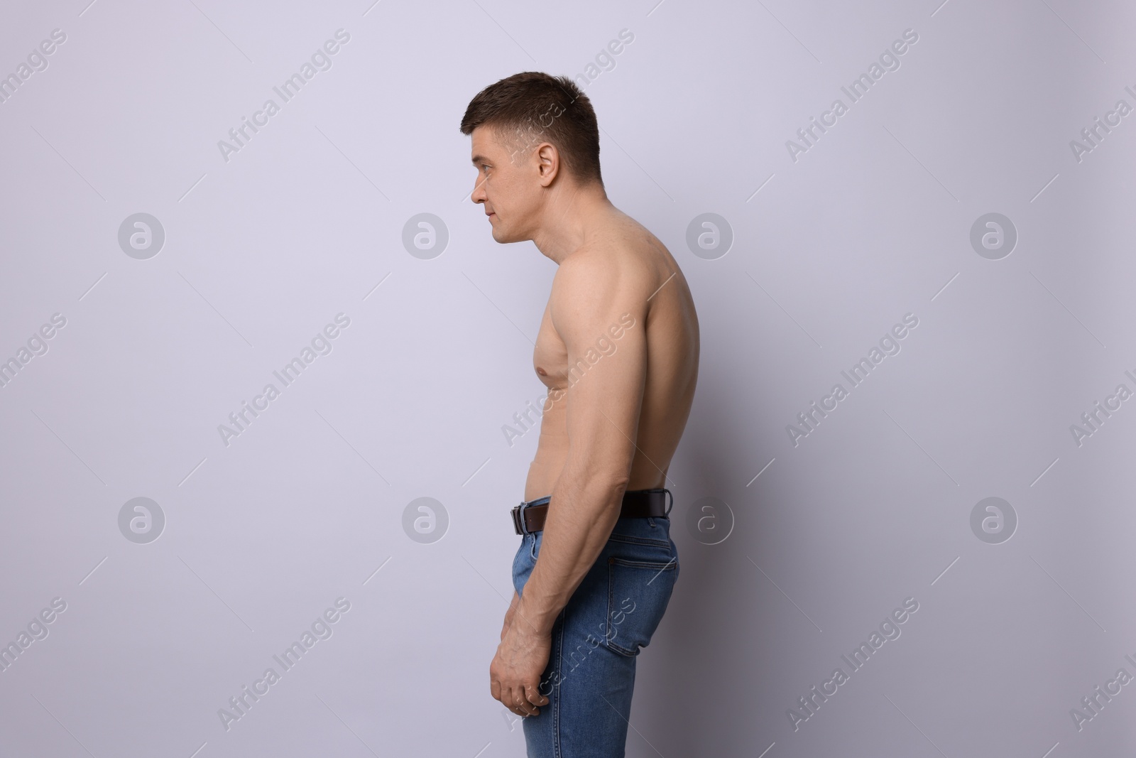 Man with bad posture on light background Photo of Man with bad posture on light background