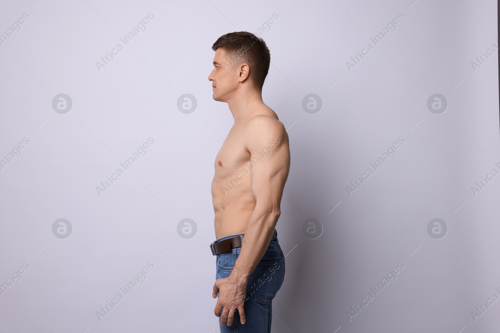 Photo of Confident shirtless man posing on light background