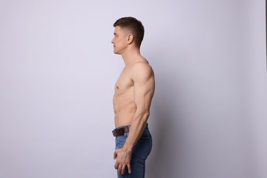 Photo of Confident shirtless man posing on light background