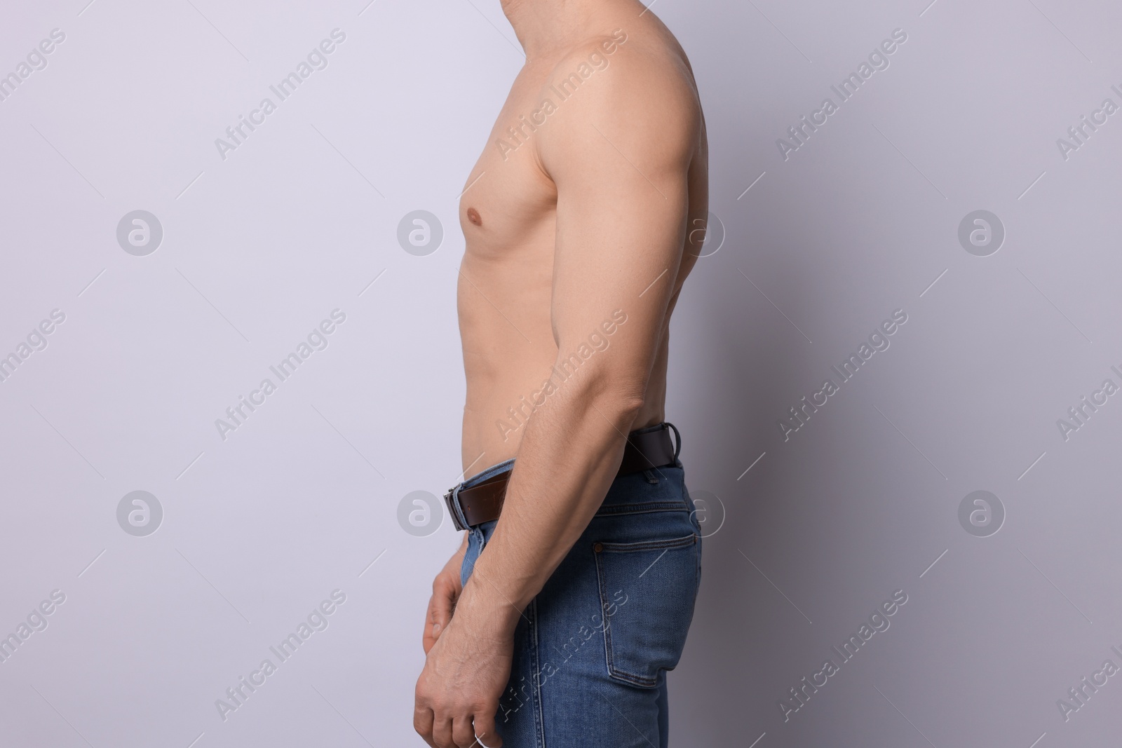 Confident shirtless man posing on light background, closeup Photo of Confident shirtless man posing on light background, closeup