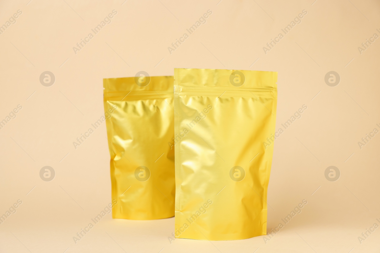 Zipper stand-up pouches on beige background. Mockup for design Photo of Zipper stand-up pouches on beige background. Mockup for design