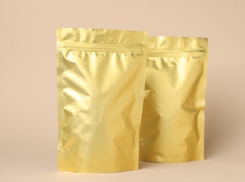 Photo of Zipper stand-up pouches on beige background. Mockup for design