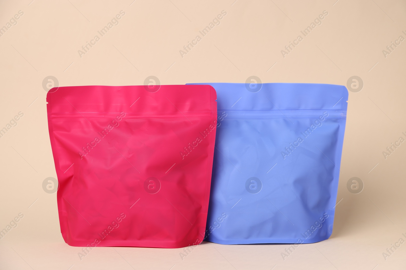 Zipper stand-up pouches on beige background. Mockup for design Photo of Zipper stand-up pouches on beige background. Mockup for design