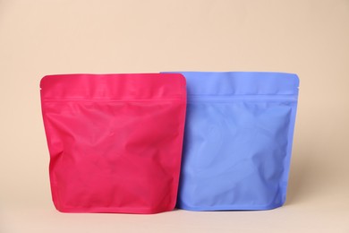 Photo of Zipper stand-up pouches on beige background. Mockup for design