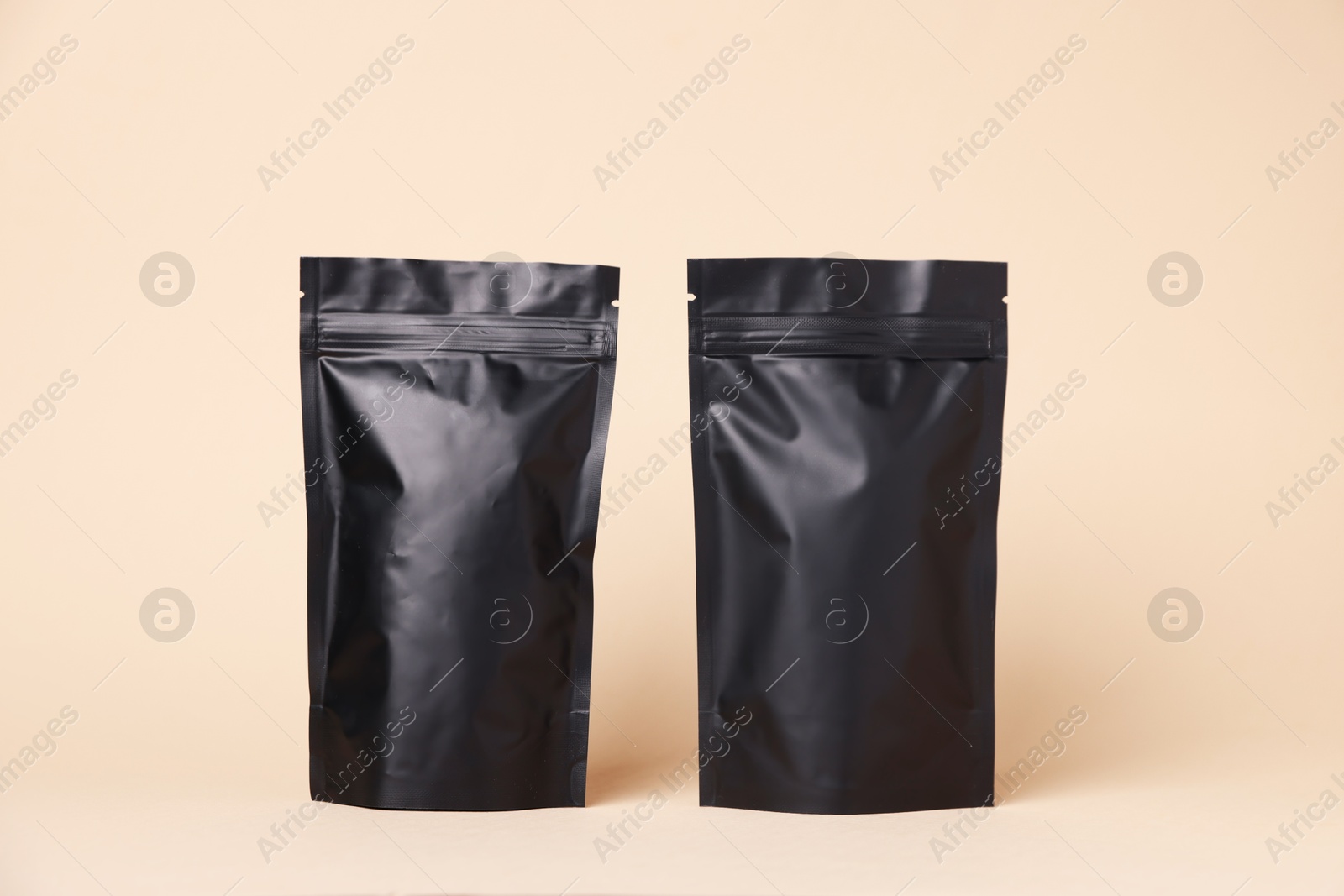 Zipper stand-up pouches on beige background. Mockup for design Photo of Zipper stand-up pouches on beige background. Mockup for design