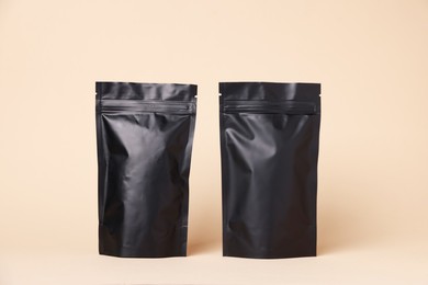 Photo of Zipper stand-up pouches on beige background. Mockup for design
