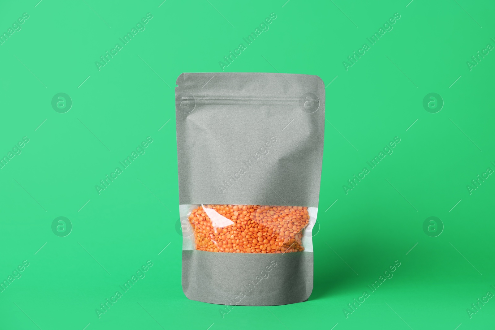 One zipper stand-up pouch with lentils on green background. Mockup for design Photo of One zipper stand-up pouch with lentils on green background. Mockup for design