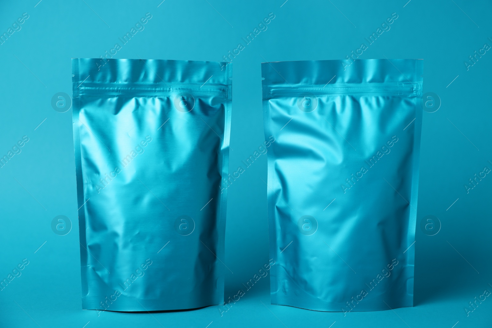 Photo of Zipper stand-up pouches on light blue background. Mockup for design