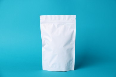 Photo of One zipper stand-up pouch on light blue background. Mockup for design