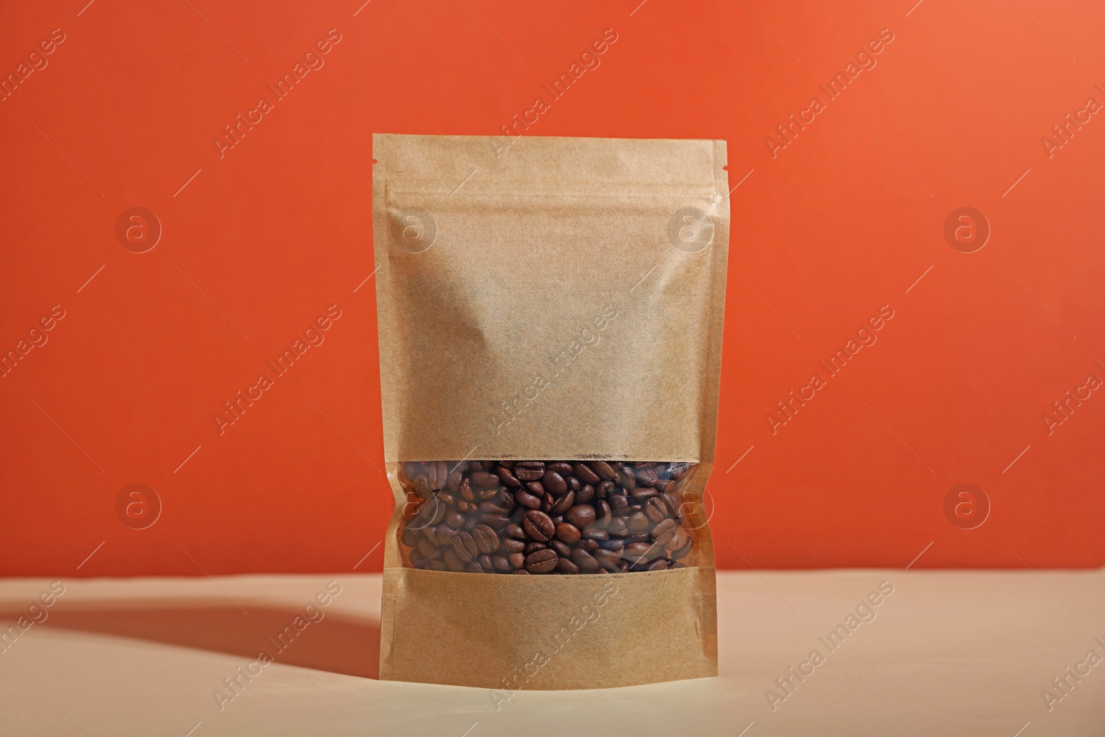 One zipper stand-up pouch with coffee beans on white table against red background. Mockup for design Photo of One zipper stand-up pouch with coffee beans on white table against red background. Mockup for design
