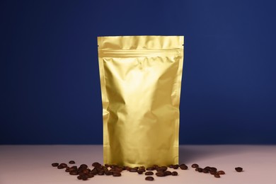 Photo of One zipper stand-up pouch with coffee beans on pink table against blue background. Mockup for design