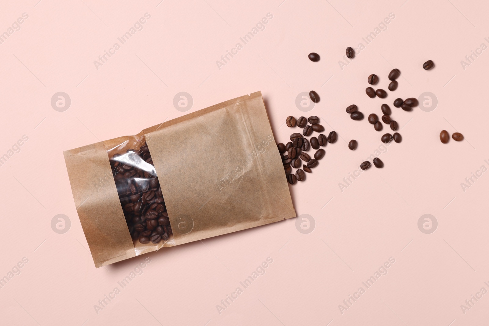Photo of One zipper stand-up pouch with coffee beans on pink background, flat lay. Mockup for design