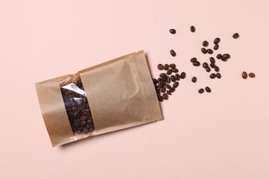Photo of One zipper stand-up pouch with coffee beans on pink background, flat lay. Mockup for design