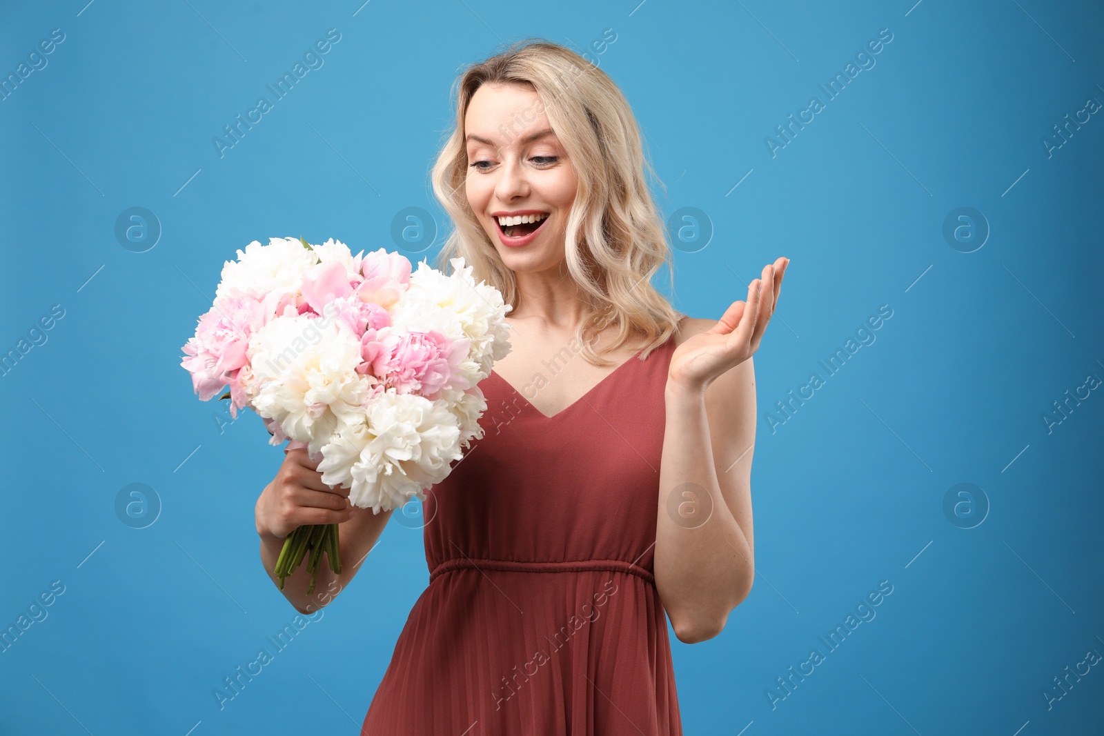 Happy woman with bouquet of beautiful peonies on light blue background Photo of Happy woman with bouquet of beautiful peonies on light blue background