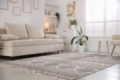 Photo of Comfortable sofa and stylish rug in room. Interior design