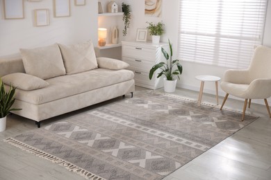Photo of Comfortable sofa and stylish rug in room. Interior design