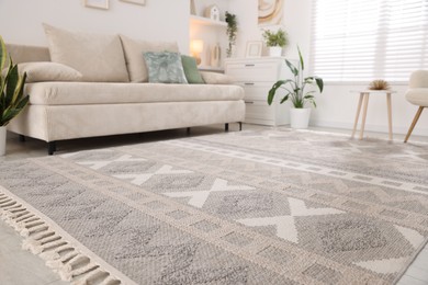 Photo of Comfortable sofa and stylish rug in room. Interior design