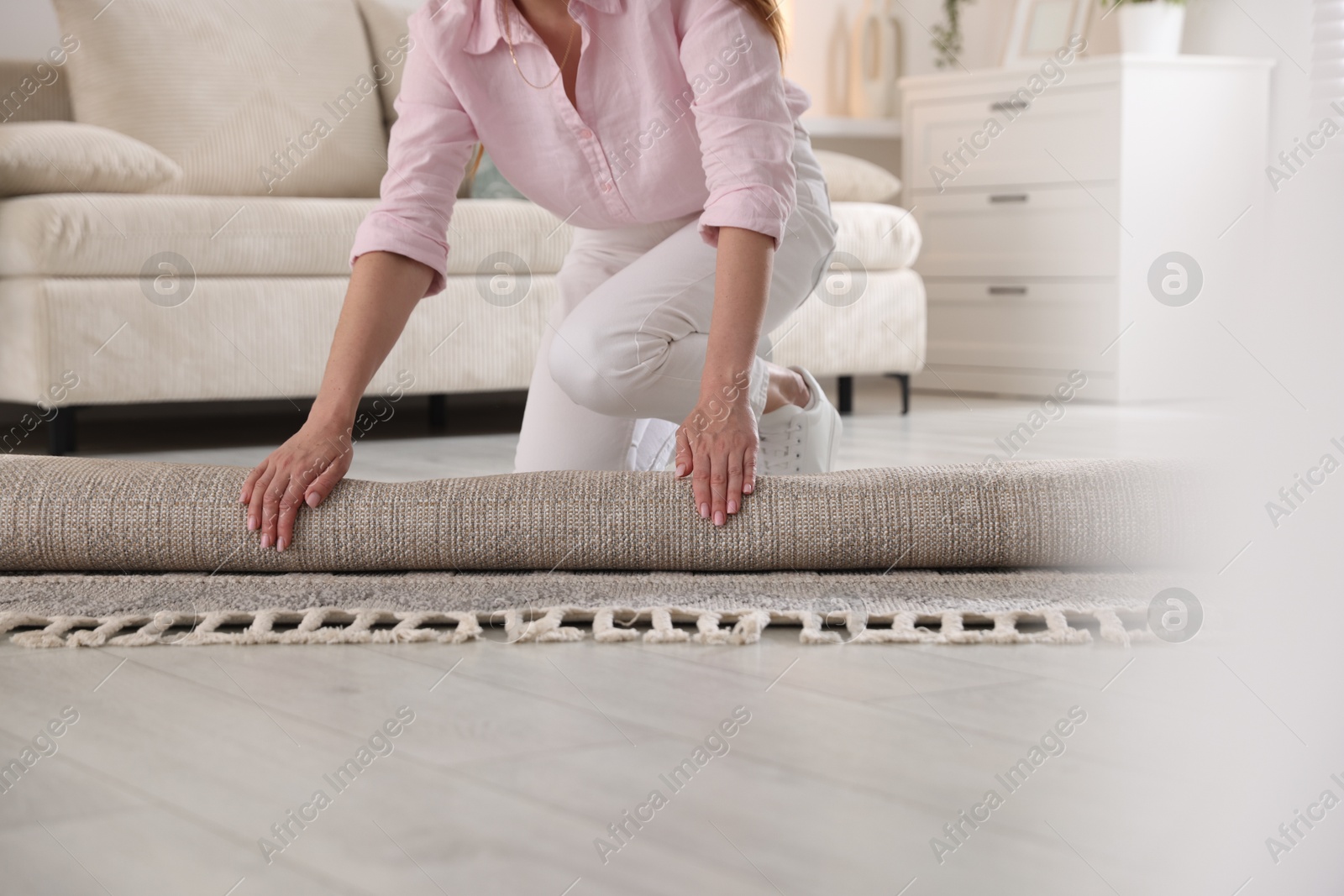 Woman putting new rug on floor at home, closeup Photo of Woman putting new rug on floor at home, closeup