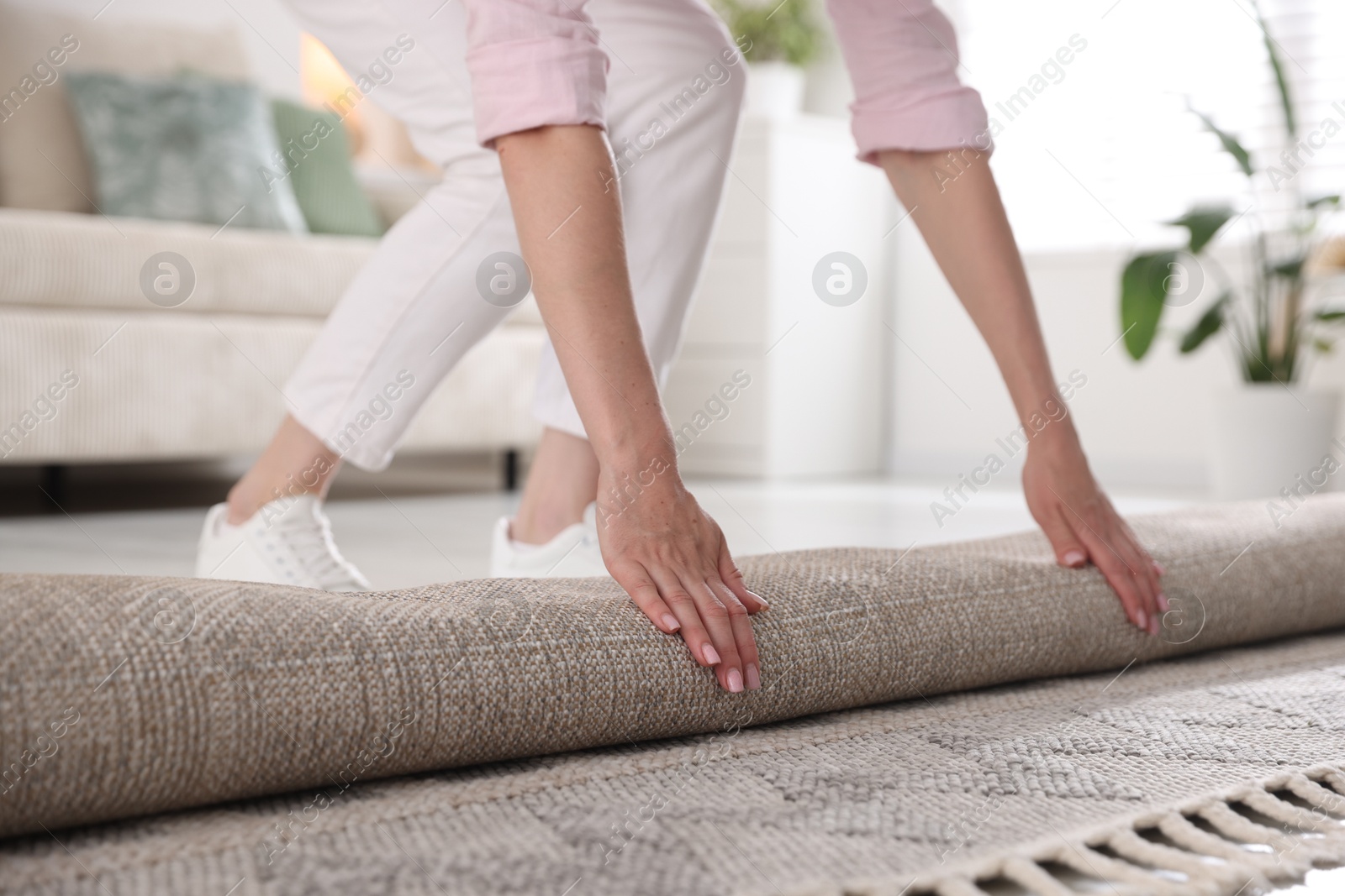 Woman putting new rug on floor at home, closeup Photo of Woman putting new rug on floor at home, closeup